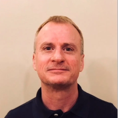 Dr. Andrew Hamilton smiling in a black shirt.