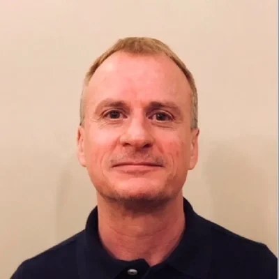 Dr. Andrew Hamilton smiling in a black shirt.